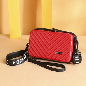 Mini red PC hardshell crossbody suitcase bag with textured V-pattern and wide strap