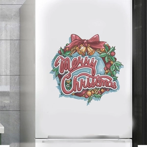 Autocollant de couronne de Noël avec Merry Christmas sur la surface d'un réfrigérateur blanc