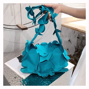 Detail of teal floral petal shoulder bag with layered textured synthetic leather design