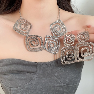 Detailed view of silver hollow spiral square necklace and earrings set on a model