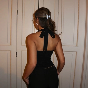 Detaillierte Rückansicht eines schwarzen Neckholder-Tops mit sexy rückenfreiem Design