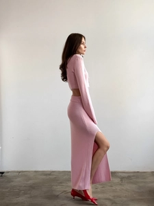 Vue détaillée d'un ensemble rose tricoté avec crop top manches longues et jupe longue fendue
