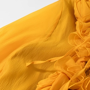 Close-up of yellow ruffled fabric with pleated texture and delicate smocked details
