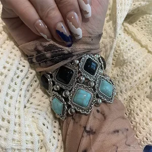 Gros plan sur un bracelet bohème en métal argenté avec pierres noires et turquoise