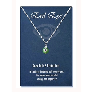 Detail view of green evil eye charm necklace on a blue good luck gift card