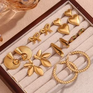 Macro view of assorted 18K gold-plated heart and floral stud earrings in a jewelry box