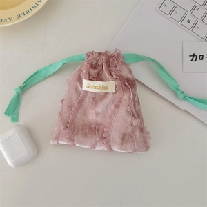 Close-up of pink velvet drawstring pouch with lace trim and mint green ribbon detail