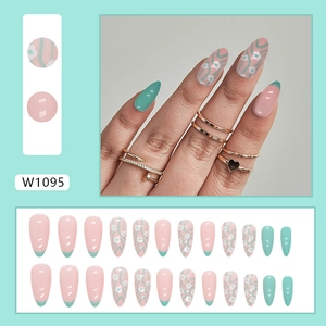 Green and pink almond press-on nails with daisy floral designs and French tips