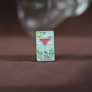 Macro shot of an enamel pin featuring tarot card theme with Margarita cocktail design