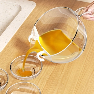 Transparent high borosilicate glass sharing pot with scale on a light wooden table