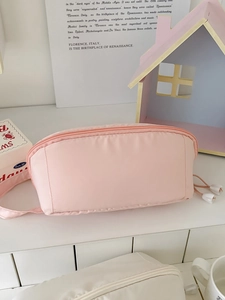 Detailed close-up of pink macaron vanity bag with smooth zipper and white drawstring detail