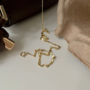 Close-up of golden 925 sterling silver flat link chain necklace with spring ring clasp