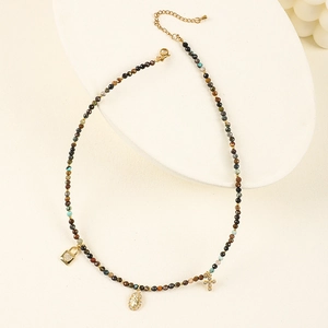 Detail of bohemian natural stone beaded necklace with gold heart and cross charms