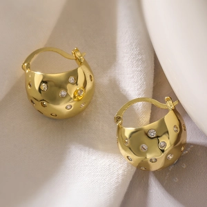 Vintage irregular geometric zircon hoop earrings with gold plating on a soft fabric backdrop