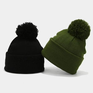Winter knitted beanies with faux fur pompoms in black and olive green for outdoor warmth