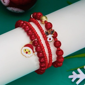 Dettaglio del set di braccialetti natalizi con perle rosse e ciondoli festivi