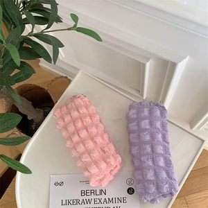 Detail view of pink and purple bubble texture pencil cases on a white tray for storage