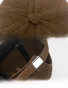 Detail of brown cotton baseball cap showing fine stitching and adjustable metal buckle