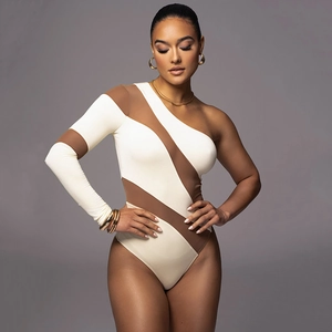 Detailed close-up of one-shoulder bodysuit with white and brown patchwork design