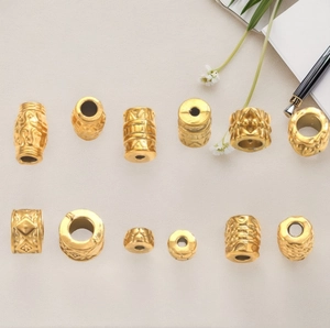 Golden stainless steel mantra beads for DIY jewelry making displayed with props