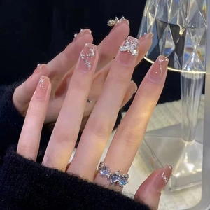 Elegant nude pink gradient press-on nails with silver rhinestone bow and pearl accents