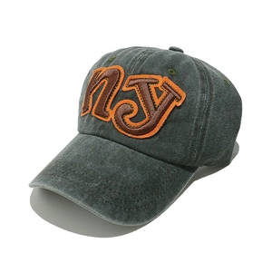 Detail of NY leather patch on grey washed cotton baseball cap with vintage finish