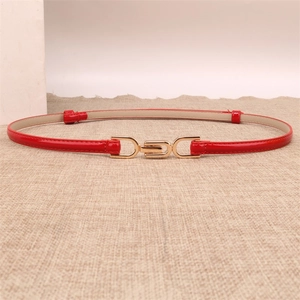 Detailed view of red patent leather thin belt with gold buckle on linen background