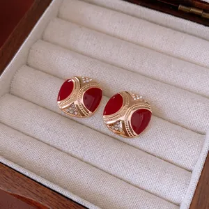 Vintage gold square earrings with red enamel and crystals on a velvet display box