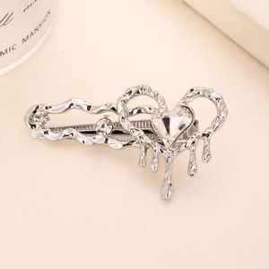 Elegant silver melting heart hair clip with cat eye stone and crystals on beige background