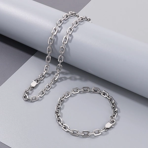 Close-up of minimalist silver stainless steel chain link necklace and bracelet set