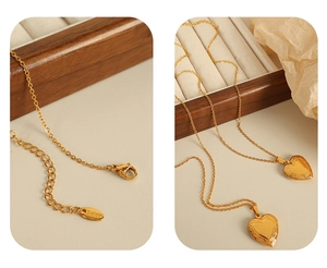 Macro detail of gold stainless steel heart locket necklace with lobster clasp and chain