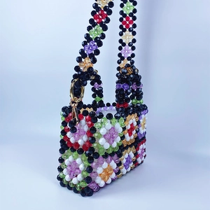 Detailed close-up of handmade beaded bag with colorful checkered flower pattern