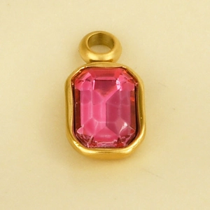 Detail of a rectangular pink faceted gemstone pendant with a polished gold stainless steel frame