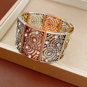 Close-up of vintage wide stretch bracelet with hollow swirl textures and inlaid rhinestones
