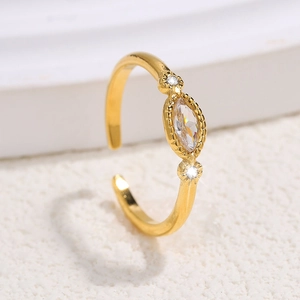 Adjustable gold stainless steel ring with marquise-cut zircon on white stone surface
