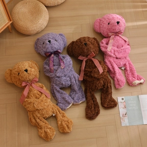Cute teddy bear plush skins in four colors with decorative bow ties on wooden floor