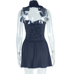 Detail of cross-back lace-up closure and ruffled halter collar on a black dress