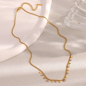 Detail of 18K gold plated necklace featuring small round disks and zircon pendants
