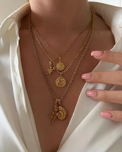 Détail de colliers superposés plaqués or 18 carats avec pendentifs soleil et ange