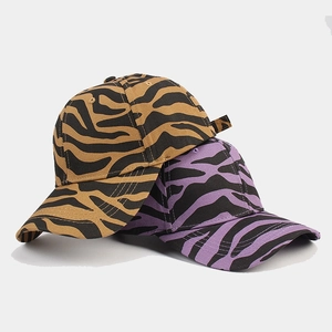 Detail view of yellow and purple zebra print baseball caps with quality stitching