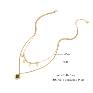 Detail view of double-layered stainless steel necklace with green square pendant and beads
