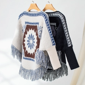 Detail of bohemian knit ponchos featuring geometric patterns and hanging fringe tassels