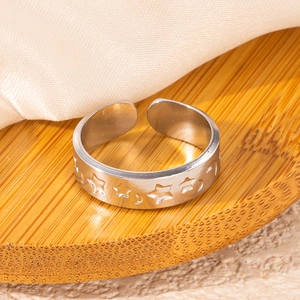 Macro view of adjustable silver ring with hollow star and moon patterns on a bamboo tray