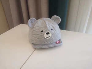 Detail view of baby sun hat featuring grey stripes, 3D bear ears and embroidered bear face