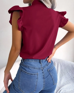 Rear view of wine red sleeveless blouse featuring elegant ruffle trim and high neckline