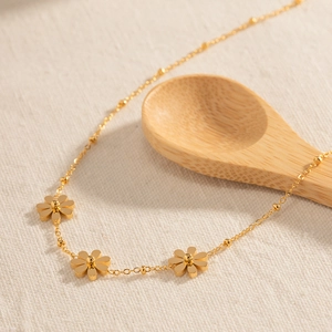 Détail macro du collier pendentif tournesol doré sur un tissu texturé naturel élégant