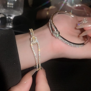 Detail van gedraaide open armbanden met fonkelende zirkonia in goud en zilver finish