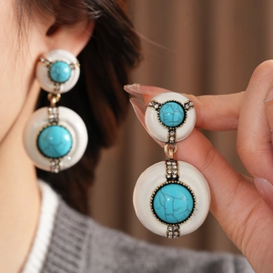 Detailed macro view of vintage resin earrings with turquoise stone and rhinestone accents