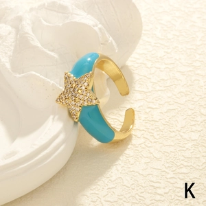 Detailed shot of golden star ring with turquoise enamel and zircon pavé accents
