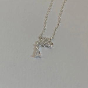 Detailed close-up of a silver crown necklace featuring a drop-shaped cubic zirconia gemstone